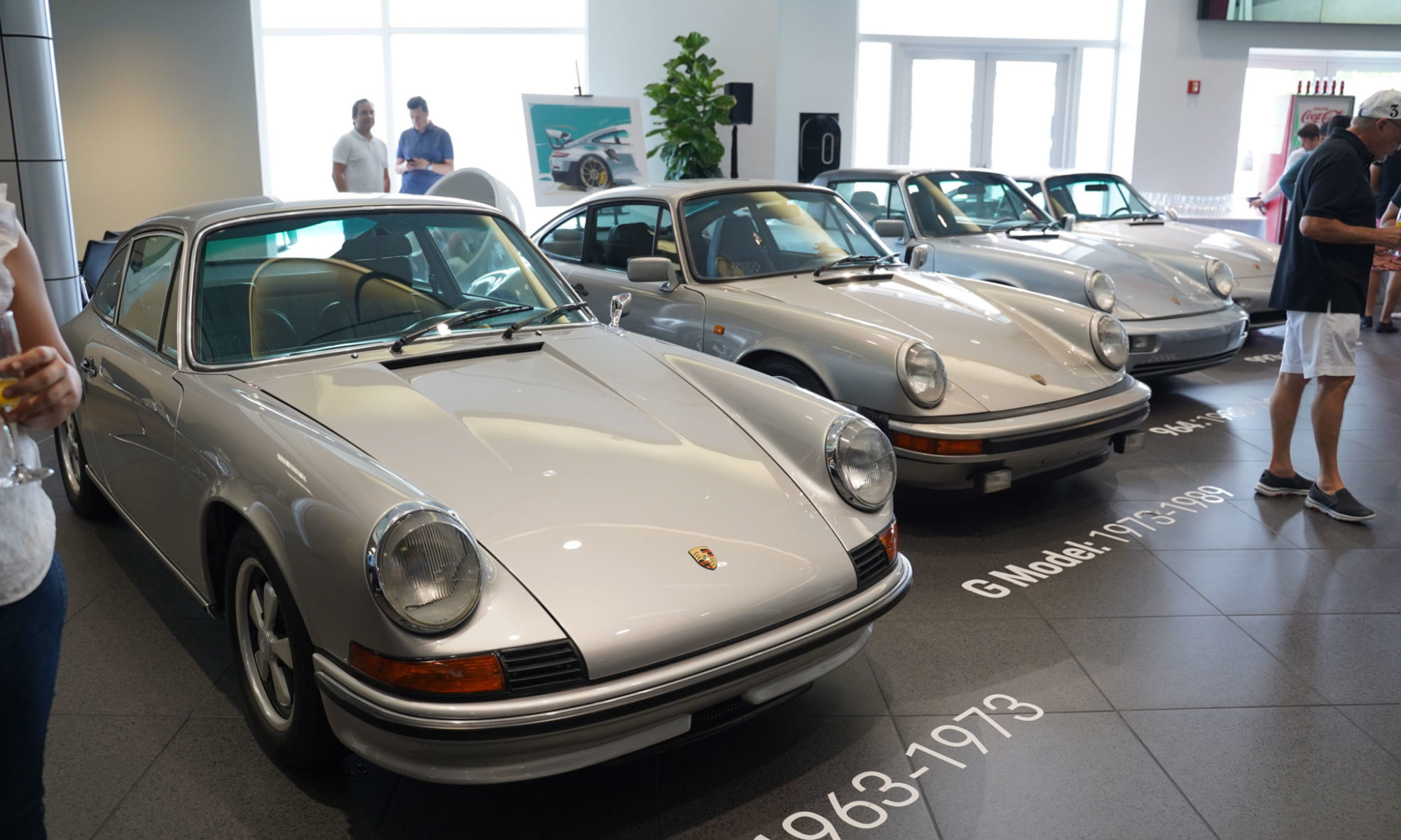 four silver porsche vehicles in a row at the september rise and drive event at the collection